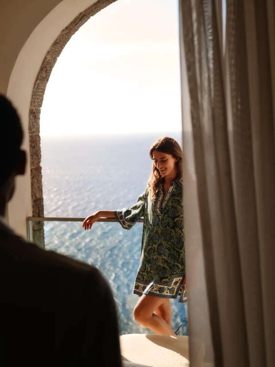 A sea-view suite with open doors and a sunlit balcony